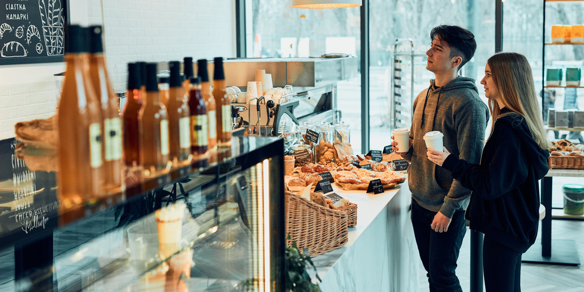 Gasten met koffie to go aan de toonbank van een café