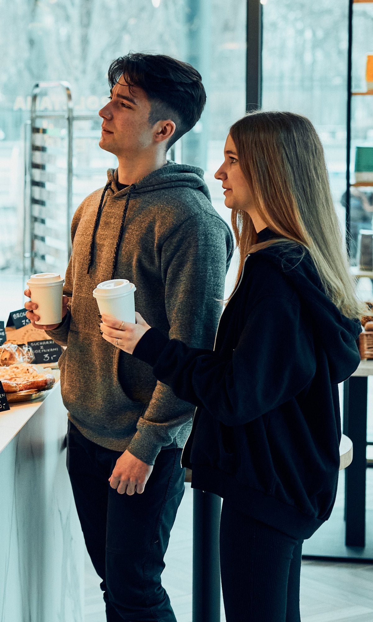 Gasten met koffie to go aan de toonbank van een café