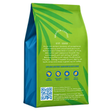 Groen met blauwe zak van Brazuca Coffee Roasters op een witte achtergrond, achterkant van de verpakking met productinformatie, iconen en een QR-code.