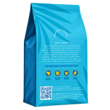 A blue coffee bag shown from the back, featuring the brand name Brazuca Coffee, establishment date Est. 2008, product description, four certification logos, a QR code, and storage instructions on a white background.